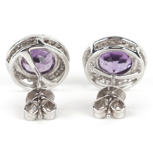 3085 - A pair of 9ct white gold amethyst and diamond cluster earrings, total diamond weight approximately 0... 