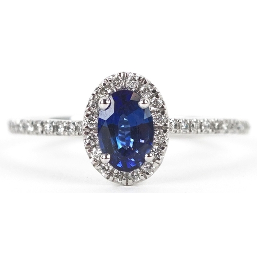 3155 - A platinum sapphire and diamond cluster ring with diamond set shoulders, total diamond weight 0.18 c... 