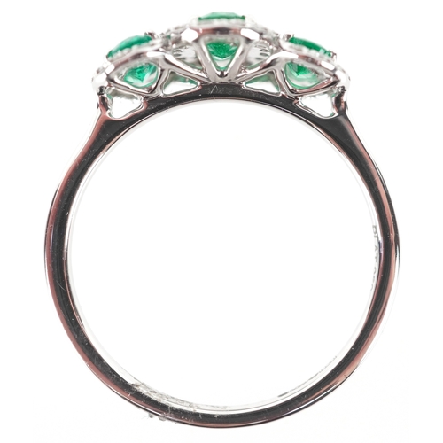 3177 - A platinum emerald and diamond trilogy ring, total diamond weight 0.22 carat, total emerald weight 0... 