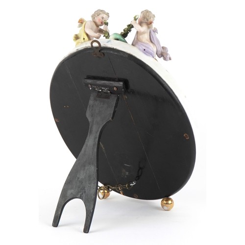 27 - A Sitzendorf German porcelain oval easel mirror with encrusted floral decoration and surmounted with... 