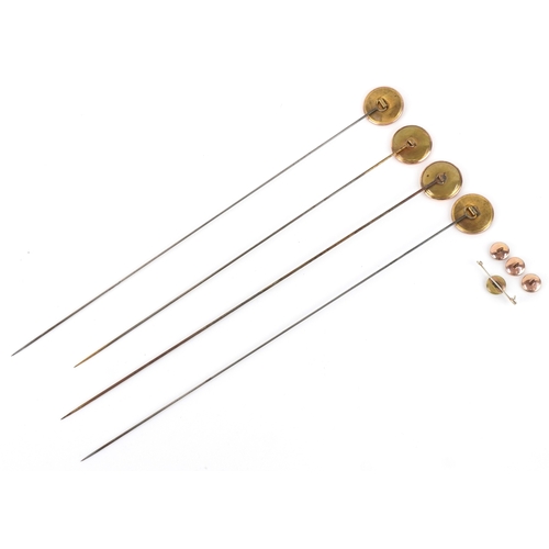 1044 - A set of four gold plated and mother-of-pearl hatpins, buttons and a broken brooch, the pins 24.5cm ... 