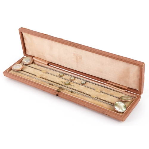 1044 - A set of four gold plated and mother-of-pearl hatpins, buttons and a broken brooch, the pins 24.5cm ... 