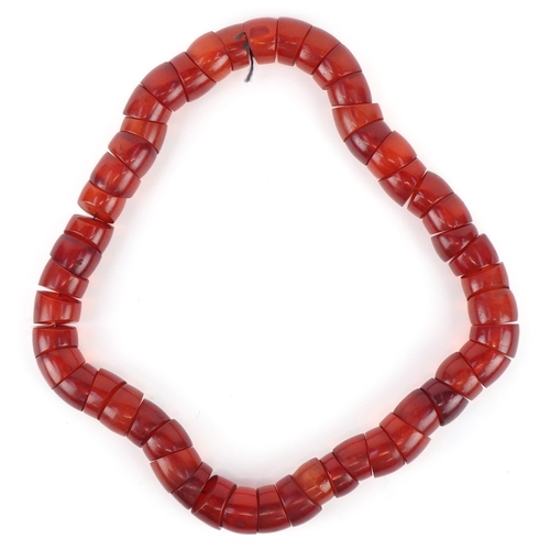 3516 - A large cherry amber coloured segmented necklace, 60cm in length x 2.5cm wide, 445.0g.