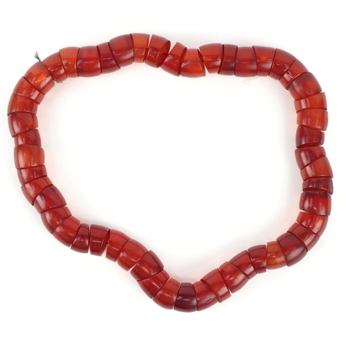 3516 - A large cherry amber coloured segmented necklace, 60cm in length x 2.5cm wide, 445.0g.