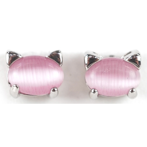 3451 - A silver and pink cat's eye pendant on chain and matching stud earrings in the form of cat heads, th... 