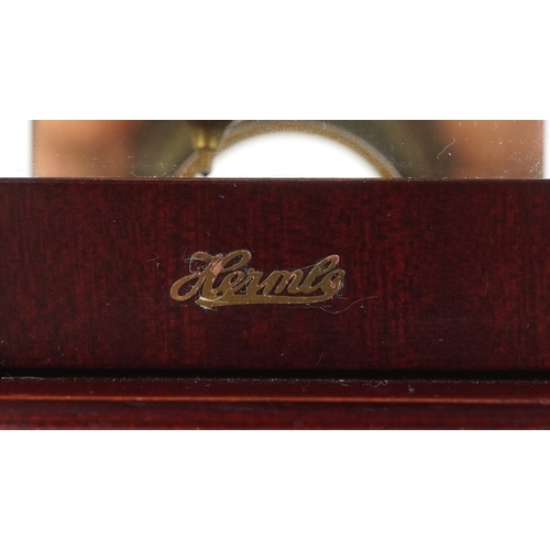25 - A late 20th century German mahogany cased mantle clock by Hermle, the silvered dial with black Roman... 