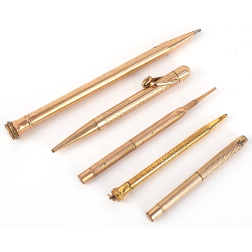 85 - Six gold plated and yellow metal propelling pencils, some with engine turned decoration including Cr... 