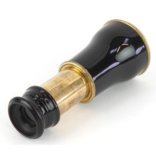 299 - An early 20th century brass and black enamel monocular, 5.5cm in length folded.