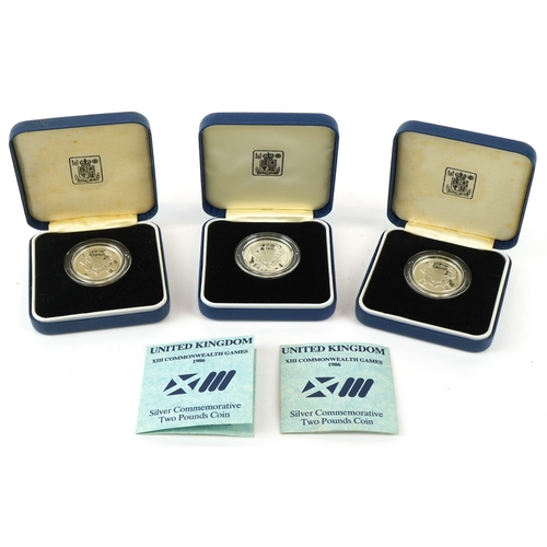 1147 - Three 1986 13th Commonwealth Games silver proof commemorative two pound coins, all in blue presentat... 