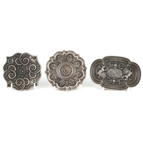 1834 - Three Chinese white metal dishes, each cast with floral decoration and animalia, the largest 12cm wi... 