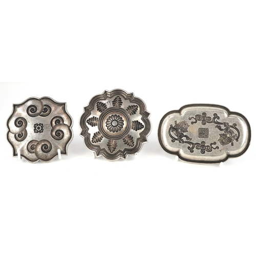 1834 - Three Chinese white metal dishes, each cast with floral decoration and animalia, the largest 12cm wi... 