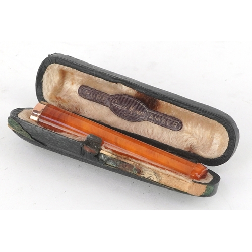 302 - Hayes & Finch, an amber coloured cheroot holder with a 9ct gold mount, Birmingham 1924, 6.5cm wide, ... 