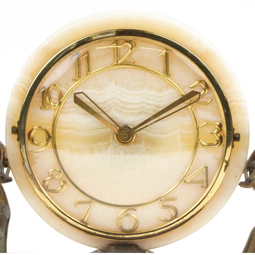 218 - An Art Deco onyx mantel clock supported by two spelter cherubs on a rectangular base, 26cm x 41cm
