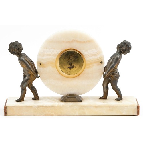 218 - An Art Deco onyx mantel clock supported by two spelter cherubs on a rectangular base, 26cm x 41cm