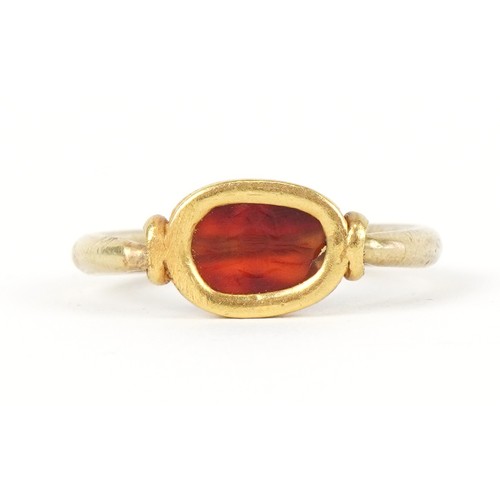 3004 - An Etruscan high carat gold carnelian scarab beetle swivel ring, size X/Y, 10.0g
