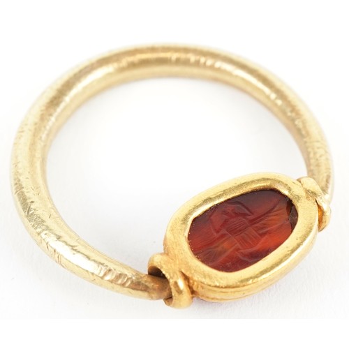 3004 - An Etruscan high carat gold carnelian scarab beetle swivel ring, size X/Y, 10.0g