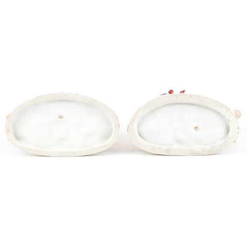  A pair of continental hand painted porcelain figures of children with cows, the largest 9.5cm high.