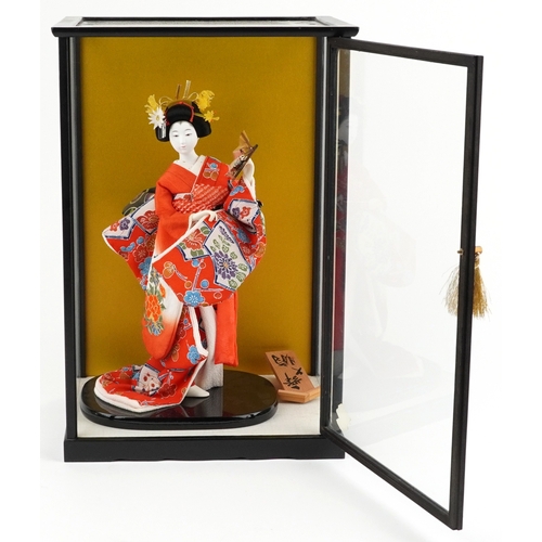 A Chinese figure of a Geisha mounted on an ebonised base within a ...