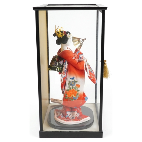 A Chinese figure of a Geisha mounted on an ebonised base within a ...