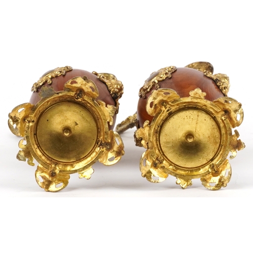  A pair of 20th century turned mahogany and gilt metal mounted decorative ewers, the scroll handles a... 
