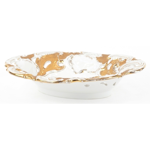 32 - A Meissen porcelain gilded and pierced oval centrepiece bowl with hand painted floral decoration, be... 
