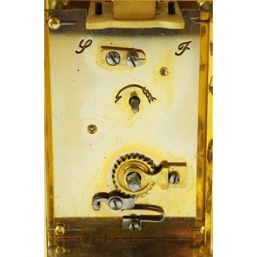 156 - A brass cased carriage clock having bevelled glass with enamelled dial and Roman numerals, 11cm high... 