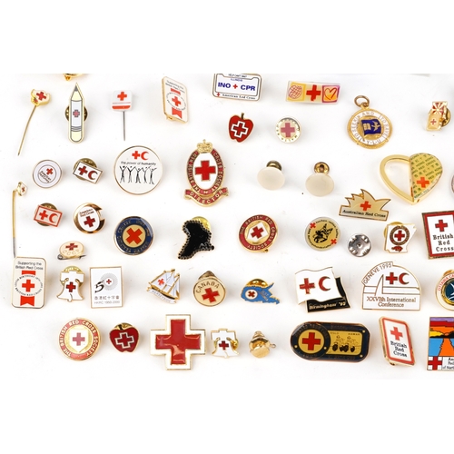 A large collection of Red Cross pin badges, lapel pins and medallions.