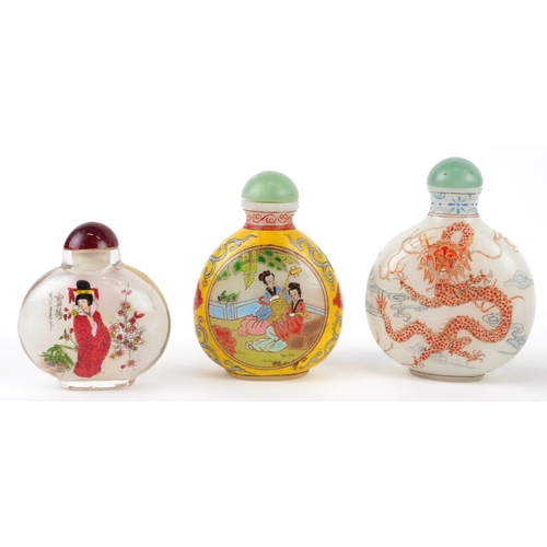 135 - Five Chinese glass snuff bottles and stoppers, each with hand painted decoration including dragons a... 