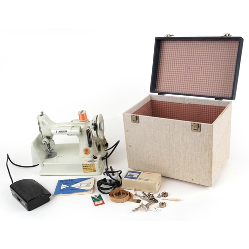 A vintage white enamelled Singer sewing machine model 221K.