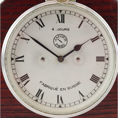 702 - Jaeger of Paris, a vintage car clock mounted in an oak stand, 19cm wide.