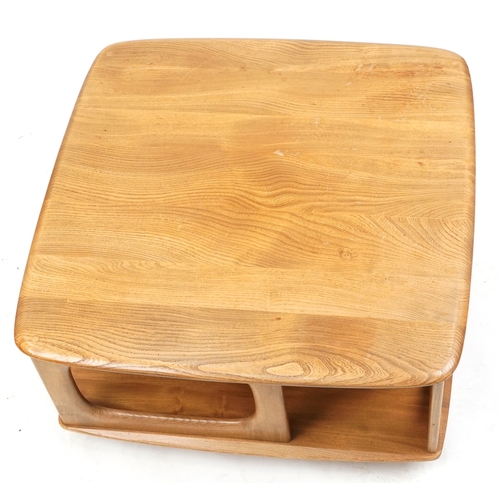 1010 - An Ercol elm square coffee table fitted with a drawer and open shelves, on casters, 41cm H x 78cm W ... 