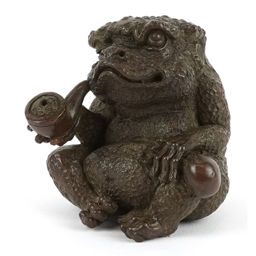 172 - A Japanese patinated bronze study of a seated toad smoking a pipe, impressed character marks to the ... 