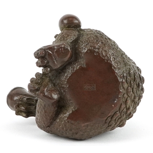 172 - A Japanese patinated bronze study of a seated toad smoking a pipe, impressed character marks to the ... 