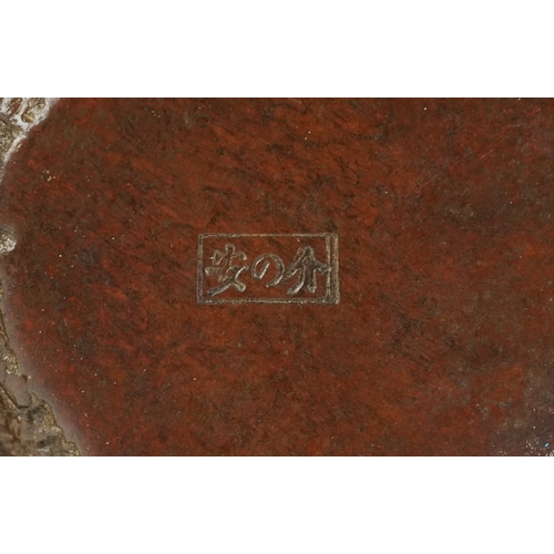 172 - A Japanese patinated bronze study of a seated toad smoking a pipe, impressed character marks to the ... 