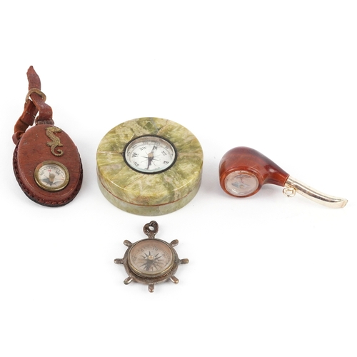 A collection of compasses including one in the form of a pipe and an ...
