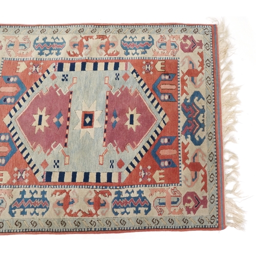 1169 - A Turkish rug, 20th century, the pink field with stylized central medallion within a complementary b... 