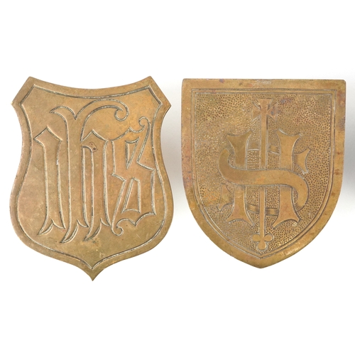 54 - Four ecclesiastical brass shield plaques/mounts including one engraved IHS, the largest 10cm high.