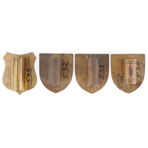 54 - Four ecclesiastical brass shield plaques/mounts including one engraved IHS, the largest 10cm high.