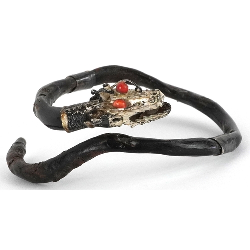 138 - An antique Chinese silver mounted gnarled wood bangle in the form of a dragon with coral eyes, 7.5cm... 