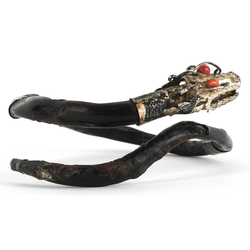 138 - An antique Chinese silver mounted gnarled wood bangle in the form of a dragon with coral eyes, 7.5cm... 