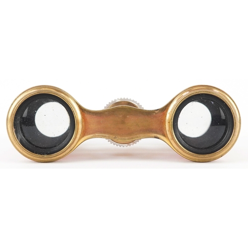 108 - A pair of early 20th century French brass and pink guilloche enamel opera glasses, 9cm wide.
