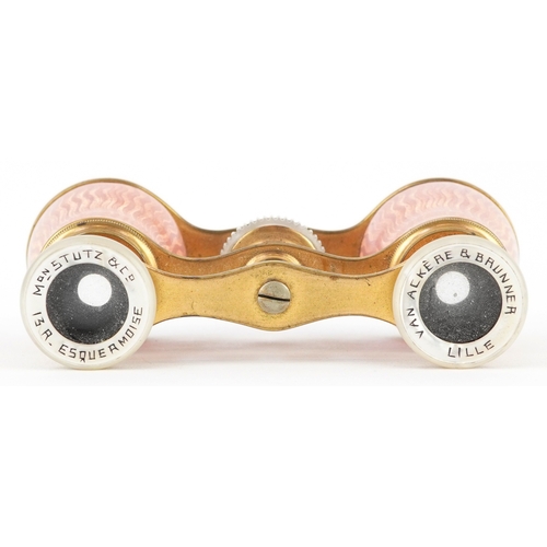 108 - A pair of early 20th century French brass and pink guilloche enamel opera glasses, 9cm wide.