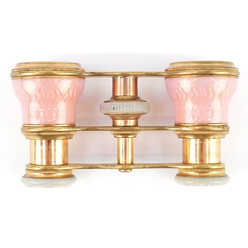108 - A pair of early 20th century French brass and pink guilloche enamel opera glasses, 9cm wide.