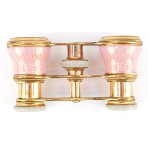 108 - A pair of early 20th century French brass and pink guilloche enamel opera glasses, 9cm wide.