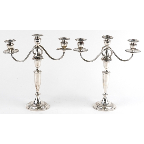  A pair of sterling silver three branch weighted candelabras, 37cm high, total 2452g.