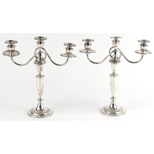  A pair of sterling silver three branch weighted candelabras, 37cm high, total 2452g.
