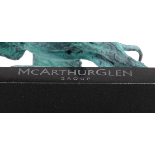 42 - Mark Coreth for McArthur Glen Group, a verdigris bronze figure of a winged lion raised on a black sl... 