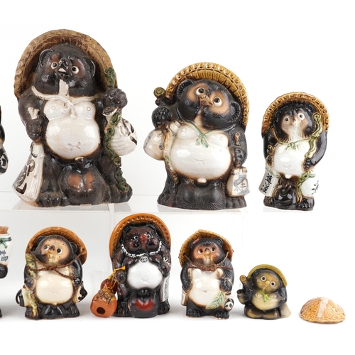 Nine Japanese pottery Tanuki figures and a Black Forest style bottle ...
