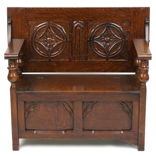  Victorian Gothic Revival oak monk's bench with carved decoration, the box seat above a panelled fron... 