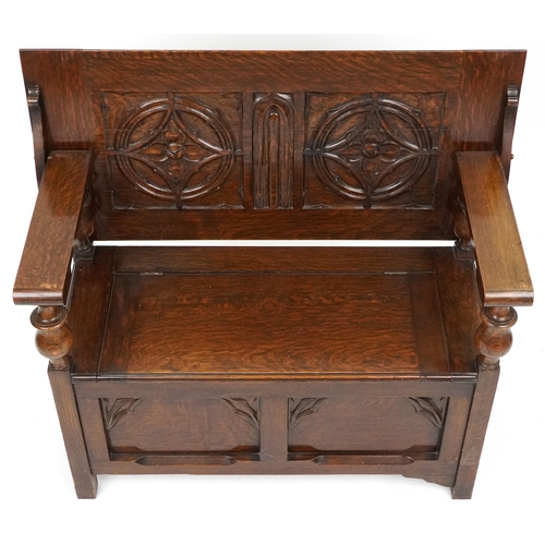  Victorian Gothic Revival oak monk's bench with carved decoration, the box seat above a panelled fron... 